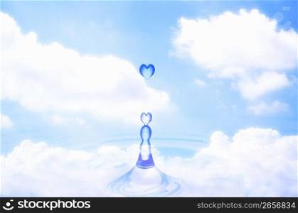 Blue heart shaped water droplets falling into the sky