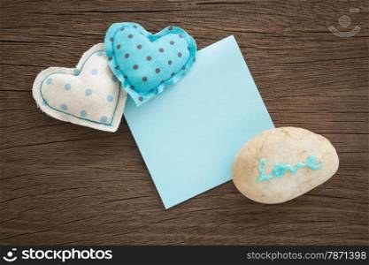 Blue hearts handmade crafts from polka dot cotton cloth with love word on pebble and blank paper note place on wood background with vignette, anniversary and valentine&rsquo;s day symbol