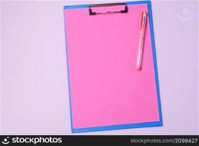 blue holder with clean pink sheets on a purple background, top view