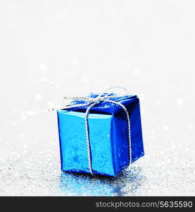 Blue holiday gift on silver glitter background