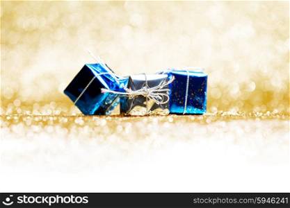 Blue holiday gifts on golden glitter background