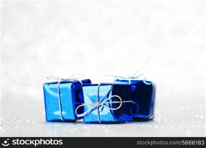 Blue holiday gifts on silver glitter background