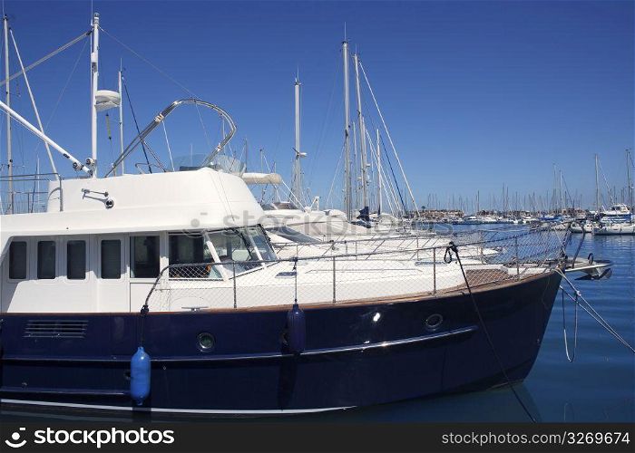 blue hull motorboat moored in mediterranean marina
