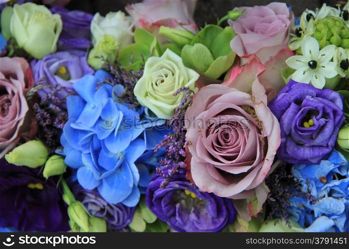 Blue hydragea and purple roses in a blue purple wedding bouquet and centerpieces