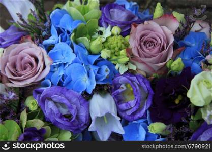 Blue hydragea and purple roses in a blue purple wedding bouquet and centerpieces