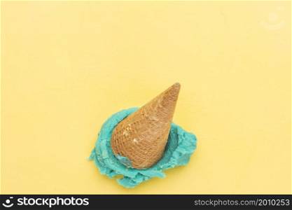 blue ice cream cone falling yellow background