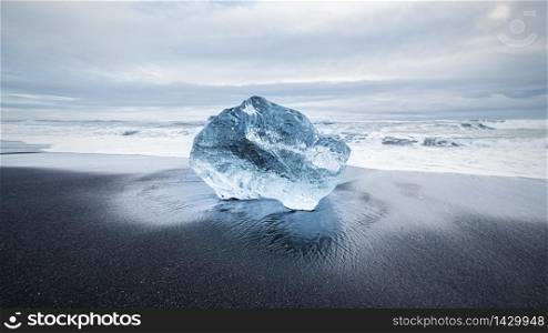 blue ice diamond on black lava sand beach near Jokulsarlon Glacier Lake, Iceland