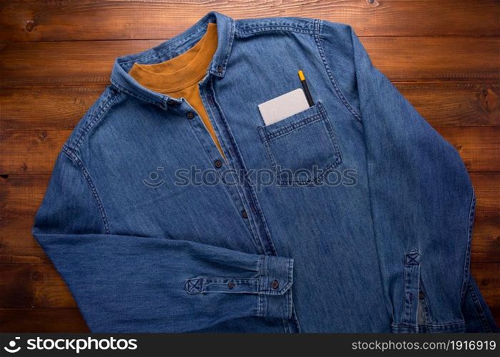 Blue jeans denim and wood background texture. Jeans material with plank wooden board