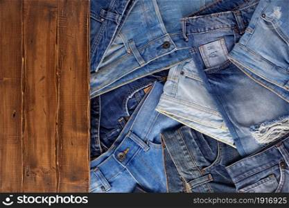 Blue jeans on wood table. Jeans heap at wooden background texture
