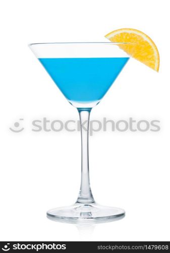 Blue lagoon summer cocktail in martini glass with orange slice on white background.