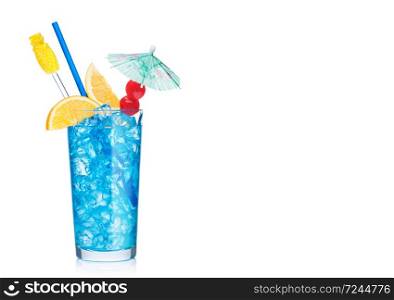 Blue lagoon summer refreshing cocktail highball glass with straw,stirrer and orange slice with sweet cherry and umbrella on white background. Vodka and blue curacao liqueur mix. Space for text