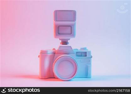 blue light vintage painted pink camera against pink backdrop