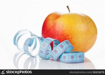 blue measure tape and red apple on white background