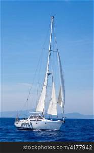 Blue Mediterranean sailboat sailing in perfect ocean