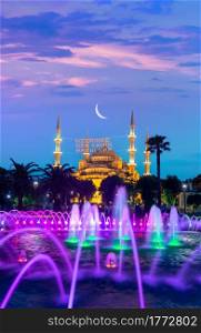 Blue Mosque illuminated at evening in Istanbul, Turkey. Inscription on a mosque is translated as On him is a soul of everyone. Blue Mosque and fountain
