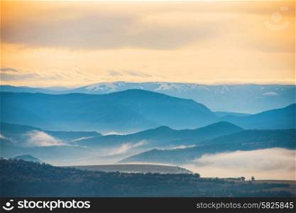 Blue mountains covered with mist against sunset