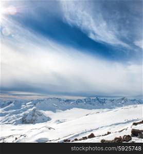 Blue mountains in clouds. Winter landscape with shining sun