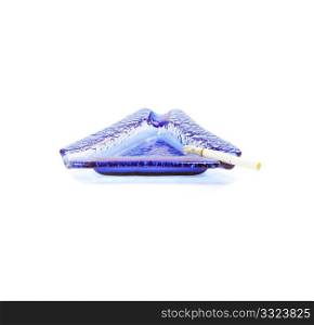 blue murano glass ashtray with lighted cigarette isolated on white background