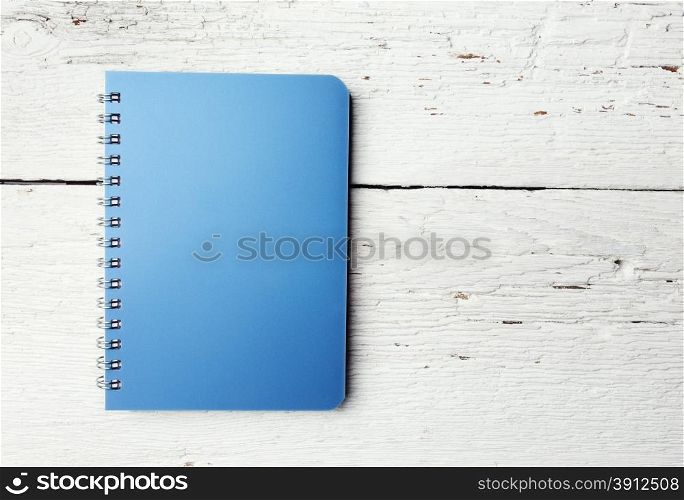 Blue notepad on white grunge wood