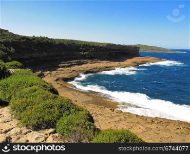 blue ocean and cliff. blue ocean, cliff, plants and tidal plattform with breaking waves