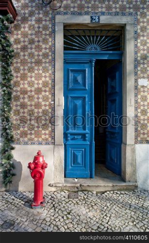 Blue painted front door and tiled building exterior with fire hydrant, Lisbon, Campo de Ourique