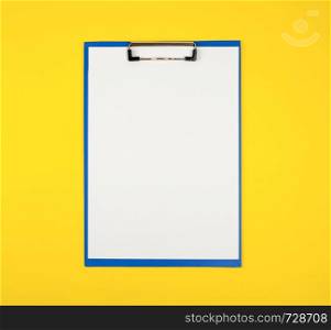 blue paper holder with white blank sheets on yellow background, copy space