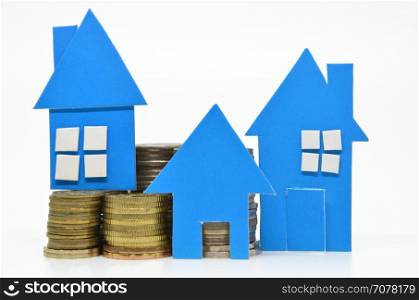 Blue paper house model and stacks of coins