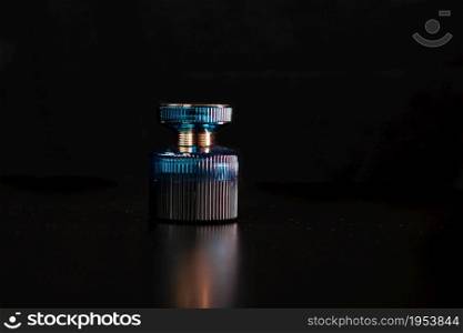 Blue perfume bottle on black background