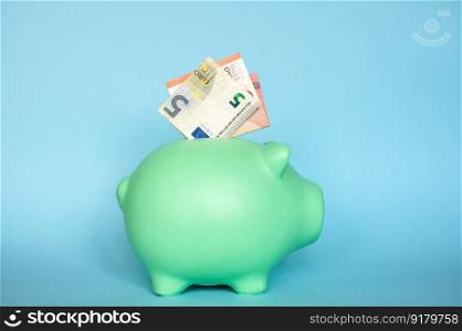 blue piggy bank with 5 euro notes. blue piggy bank with 10 and 5 euro notes