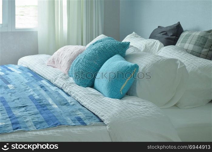 Blue pillows and blue blanket on white linen bedding