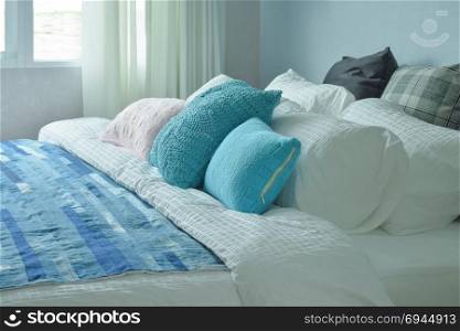 Blue pillows and blue blanket on white linen bedding