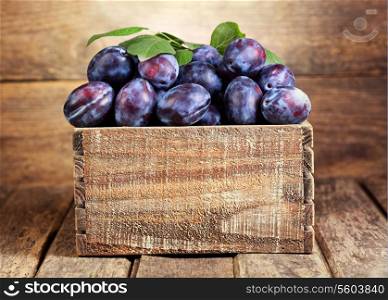 blue plums in a wooden box