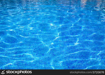 Blue pool water with sun reflections