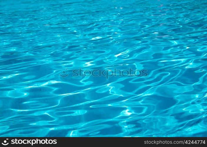 Blue pool water with sun reflections