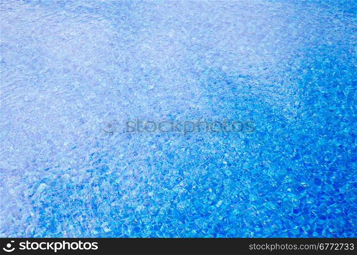 Blue pool water with sun reflections