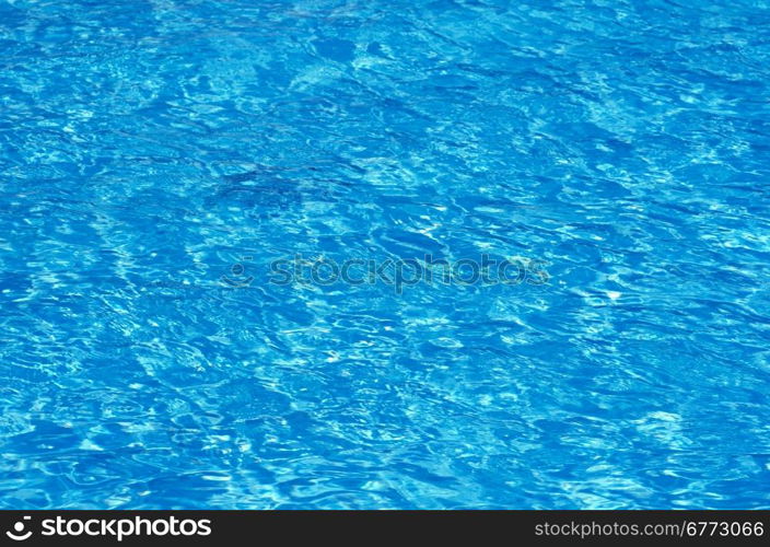 Blue pool water with sun reflections