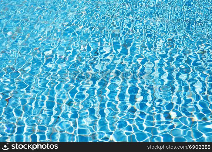 Blue pool water with sun reflections