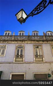 Blue portuguese tiles on house wall with cracks and latnern in the sky&#xA;