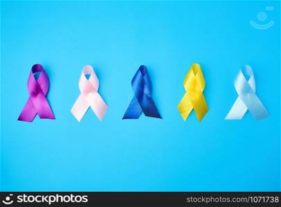 blue, purple, yellow, blue, pink ribbon in the form of a bow, international symbols of diseases on a blue background