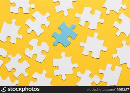 blue puzzle with white jigsaw piece yellow background