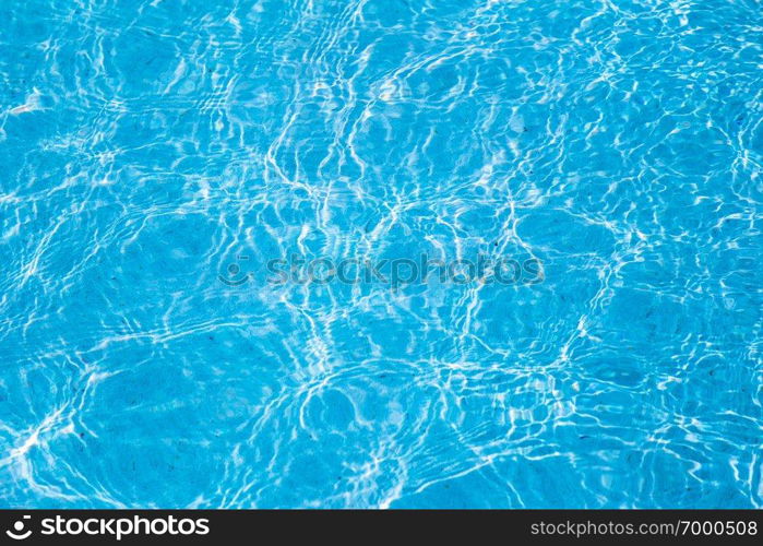 Blue ripped water in swimming pool with sunny reflections.