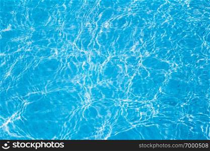 Blue ripped water in swimming pool with sunny reflections.