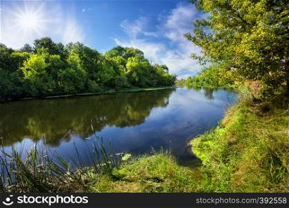 Blue river with green trees on the shore during the day. Blue river with green trees on the shore