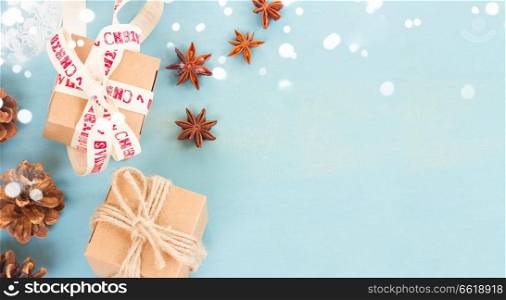 Blue rustic christmas - styled christmas composition flat lay style with gift boxes , spices and cones banner with copy space. Blue rustic christmas