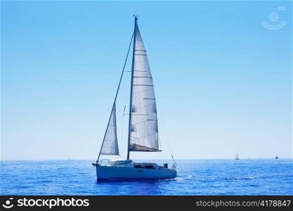 blue sailboat sailing mediterranean sea with water horizon