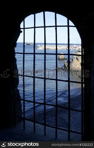 Blue sea behind the jail, arch window