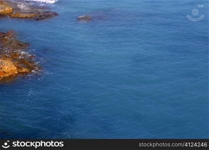 Blue sea ocean coastline with rocks on left shore