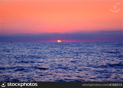 blue sea sunrise with sun in horizon and red sky