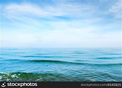 Blue sea water with waves and white clouds on the sky. Calm tropical landscape. Blue sea water with waves