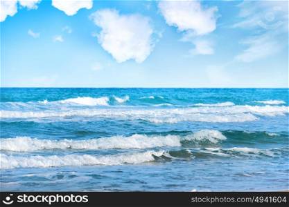 Blue sea with waves and white clouds